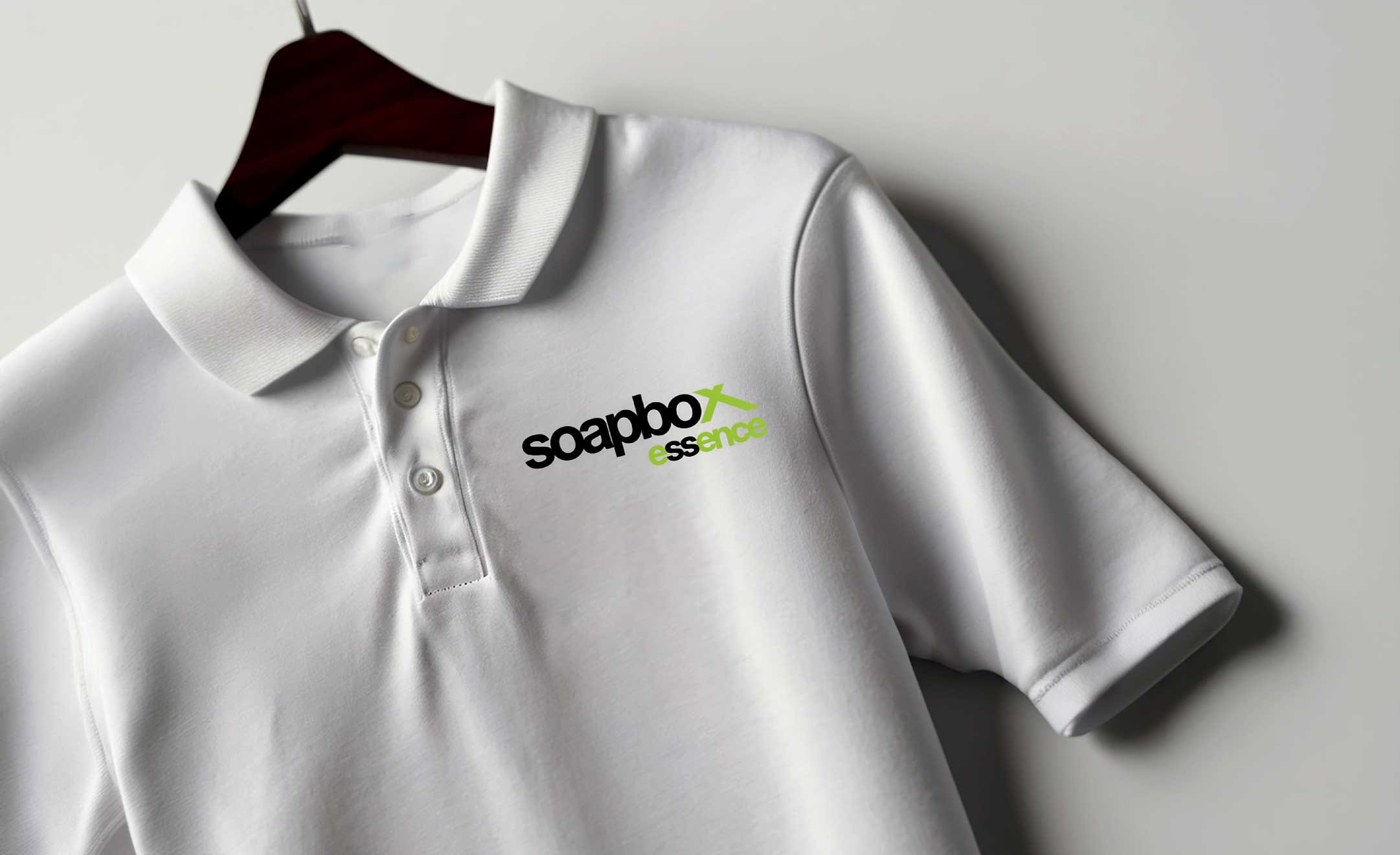 Soapbox Essence branded white corporate polo on a hanger